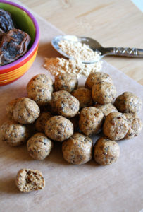 Cutting board with protein balls, maca powder, and dates