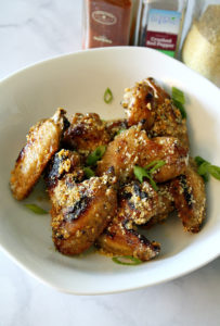 White bowl filled with wings with garlic and vegan parmesan sauce