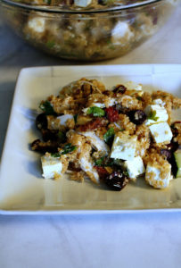 White plate with quinoa and Greek flavors