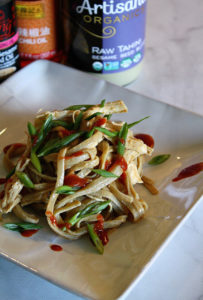 White plate on marble with Spicy Sesame Chicken Noodles